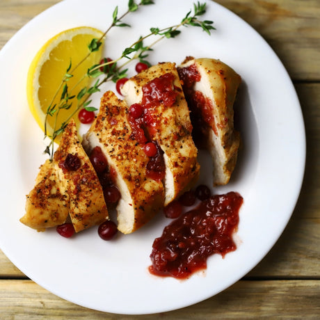 image of turkey breast with cranberry sauce and lemon wedge